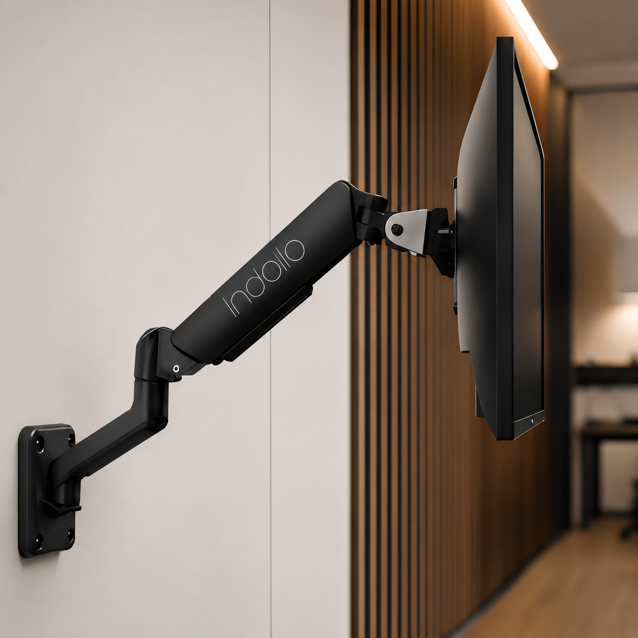 Indalio wall mounted gas-spring monitor arm installed on a workspace wall